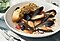 Steamed mussels and roasted rainbow roots paired with white garlic bread on it are in an white bowl.