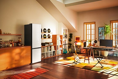Two 1-door Steel Black and a 2-door Steel Black Bespoke refrigerators are placed next to each other in a modern kitchen. The 2-door unit's top door is open.