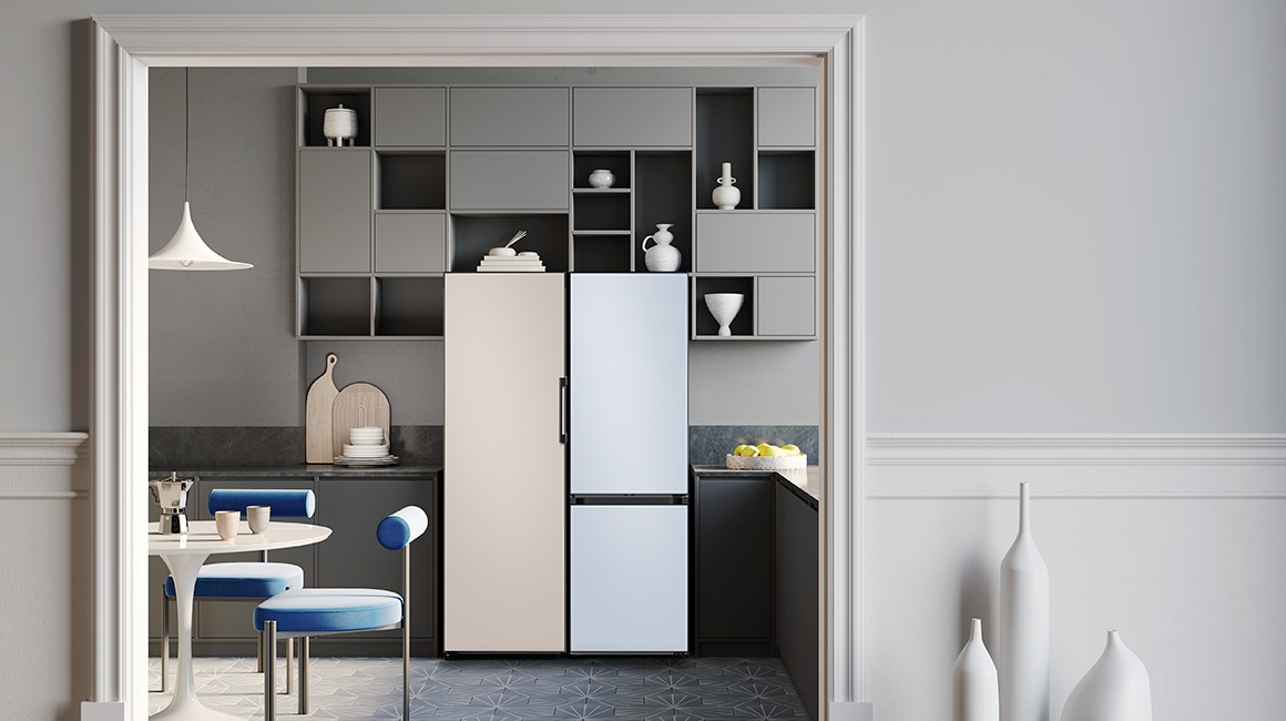 A 2-door Bespoke refrigerator with Cotta Beige panel on top and Cotta Lavender panel on the bottom is in a stylish white and purple themed kitchen next to a window.