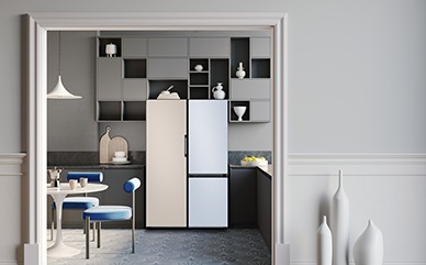 A 2-door Bespoke refrigerator with Cotta Beige panel on top and Cotta Lavender panel on the bottom is in a stylish white and purple themed kitchen next to a window.