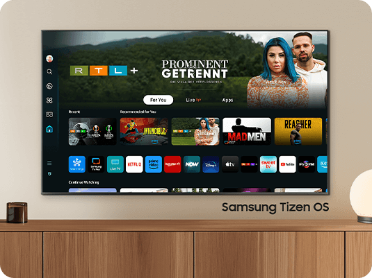 The 2024 Samsung OLED TV displays various free channels and streaming content on the Samsung Tizen OS home screen.