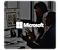 A man and woman talk on video call on a Samsung monitor. A dark overlay and white Mircosoft logo are placed over the image