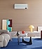 The WindFree air conditioner is hanging from a wall in a living room with a blue rug, a sofa and a coffee table. The WindFree air conditioner is hanging from a wall in a living room with a blue rug, a sofa and a coffee table.