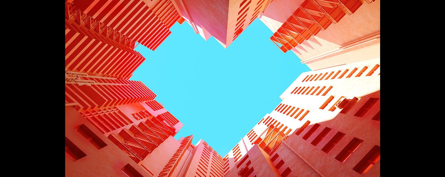 Red buildings clustered together are shot from the ground up and surround the phrase design is everywhere written on the sky.