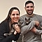 Man and woman holding cats their arms, smiling