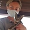 A woman wearing a mask holding a cat