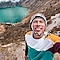 Man wearing knitted hat smiling with blue lake in the background