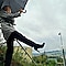Woman kicking her legs in the air holding an umbrella