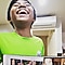 A boy in green shirt holding a photo album and smiling