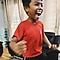 Boy in a red shirt smiling and raising his arms in the air the joy