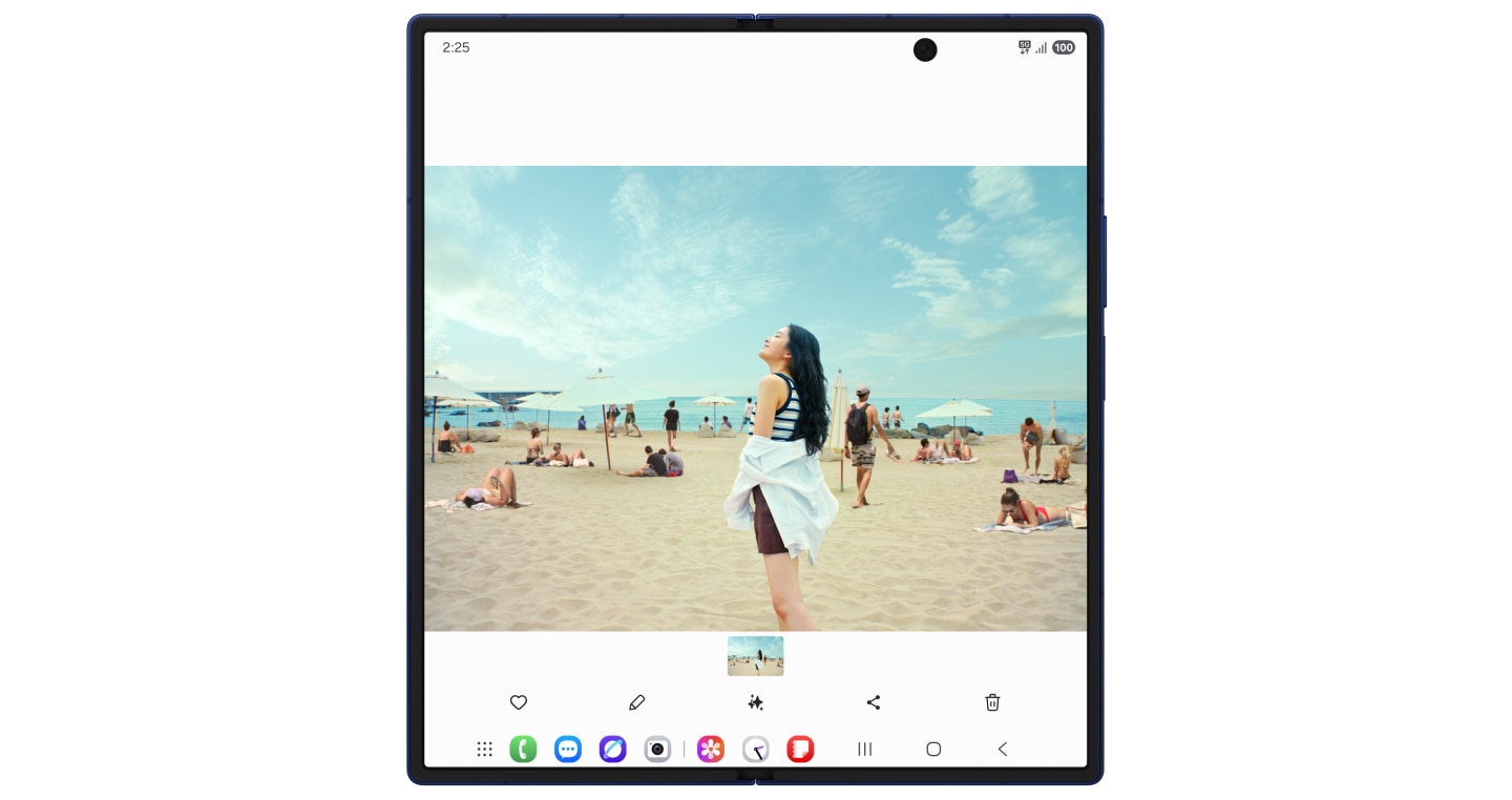 Galaxy Z Fold7ـێکی کراوە بە ڕەنگی سێبەری شین وێنەی ژنێک لە کەنار دەریا لەسەر شاشە سەرەکیەکەی نمایشدەکات. پەنجە بە ئایکۆنی Galaxy AI نراوە. Photo Assist دەردەکەوێت لەگەڵ بژاردەکانی Generative Edit و Sketch to Image. Generative Edit ڕێگەت پێدەدات پەنجە لەسەر هەر شتێک دابگریت یان هێڵی لە دەوری بکێشیت بۆ ئەوەی بیگوازیتەوە یان بیسڕیتەوە. پەنجە بنێ بە ئایکۆنی Object Eraser کە لە گۆشەی ڕاستی سەرەوەی شاشەکە دەردەکەوێت، کە شێوەکانی تر لەسەر کەنار دەریا دەدۆزێتەوە و دیاری دەکات. پەنجە بە ئایکۆنی سڕەرەکەوە بنێ کە نزیک لە ناوەڕاستی شاشەکە دەردەکەوێت. شێوە دەستنیشانکراوەکان دیار نامێنن. پەنجە بە دوگمەی بەرهەمهێنان دەنرێت، دەبێتە هۆی پاککردنەوەی دیمەنەکە بە بەکارهێنانی Galaxy AI کە وێنەکە بر وردەکارییەوە پڕدەکاتەوە. بژاردەکانی پیشاندانی وێنەی ڕەسەن و پاشەکەوتکردنی کۆپی لەسەر شاشەکە دەردەکەون.