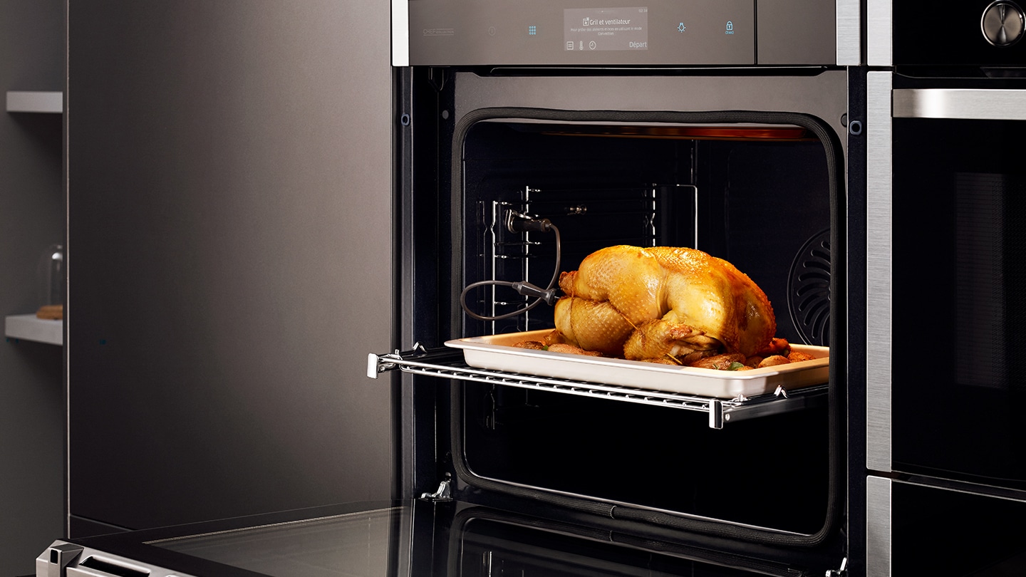 Un intero pollo arrosto è sul ripiano superiore di un forno Samsung.
