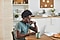 Un uomo siede al tavolo della sua cucina davanti a laptop Galaxy Book Pro. Inoltre indossa un paio di Galaxy Buds Pro.