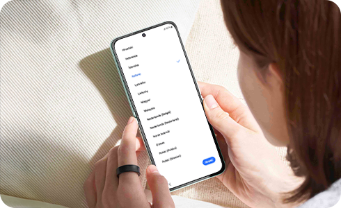 Donna che tiene uno smartphone mentre guarda lo schermo.