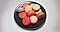 Un piatto marrone con 11 macaron rosa.