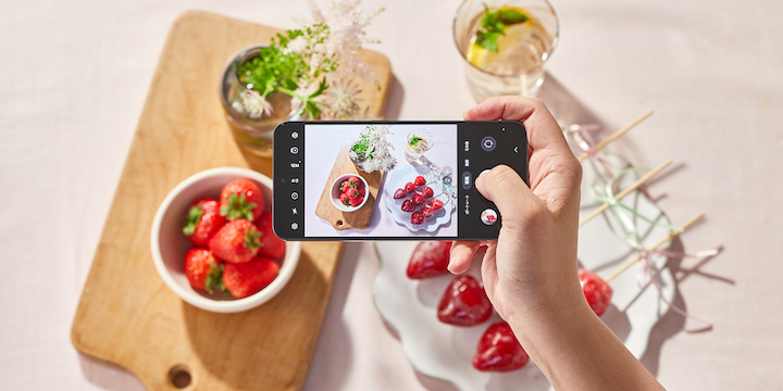 テーブルの上に並べられたイチゴと、タンフルと呼ばれるイチゴ飴がGalaxy S24(ギャラクシーS24)で真上から撮影されている。