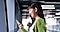 女性がスマホを手に持ち微笑んでいる。
