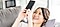 女性がソファに仰向けで寝ころびながらスマホを持って笑っている。