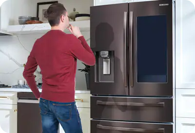 Мужчина смотрит на холодильник