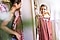 A woman is looking at a red dress with a white dot pattern for cool pictures to take on vacation.