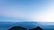 Top view of a mountain range with a clear landscape under blue gradient of clear skies.