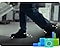 A person's feet are shown sideways and in a close-up, as he/she is carrying a white appliance on a trolley to be recycled. There are illustrations of devices and appliances in green and blue hues on the bottom right along with white illustrations of particles moving with the person's feet.