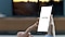 يشير الإصبع إلى هاتف محمول. تعرض شاشة الهاتف المحمول تطبيق SmartThings.