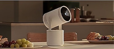 يستقر جهاز العرض على طاولة بجوار أطباق الطعام. وتنبعث منه أشعة ضوئية، وهو ما يشير إلى أنه يشغِّل محتوى.