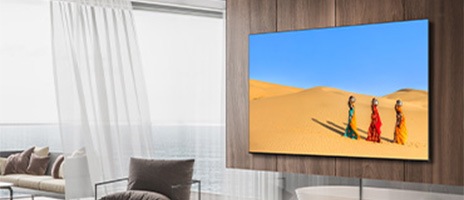Wall-mounted Samsung TV with three women walking on the desert while putting