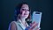 Millie Bobby Brown smiles as she looks at a ghost white Galaxy A80 in her hand