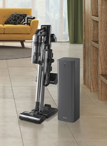 Samsung Jet 90 novietots vertikāli uz Z-stacijas ar dažādiem uzgaļiem blakus tīrīšanas stacijai.