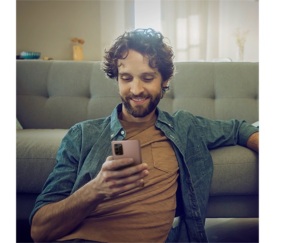 Attēlots, kā vīrietis ar Galaxy Note20 viedtālruni mistiskā bronzas krāsā pārvalda veļas mazgāšanas procesu.