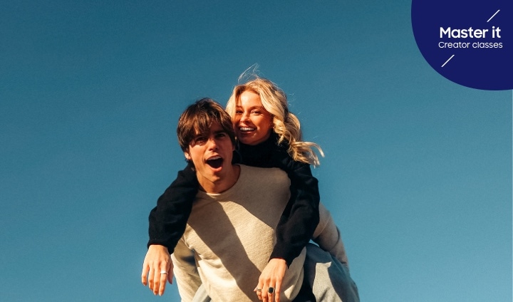 Retrato en pareja de un hombre con una mujer en su espalda riendo. Domínalo. Clases para creadores.