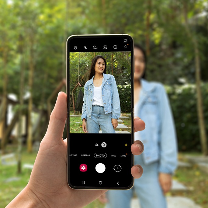 A girl standing in the centre of landscape with Galaxy Z flip 3