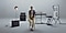SUGA of BTS sitting in a stool, standing in the middle of an empty music studio. He’s surrounded by musical instruments. There is a speaker on the left side of the room and three electronic keyboards on the right.