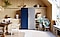 Two 1-door Bespoke refrigerators are placed next to each other in a stylish dining room with plants. The color of the left one is a Glam Navy and the right one is Satin Gray. The handles are placed in the center so the doors open outwards.