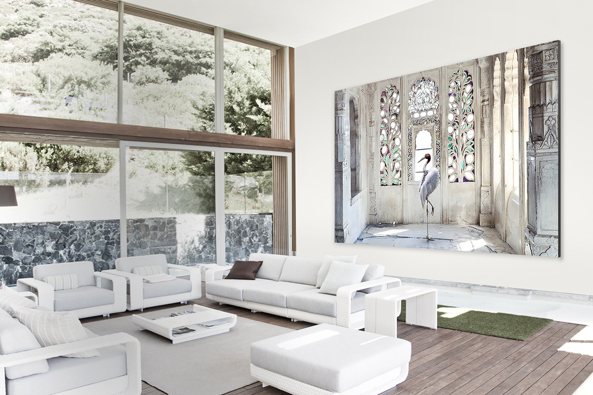 The Wall in a bright living room with high windows and ceiling displaying a renowned photograph of a crane in a palace.