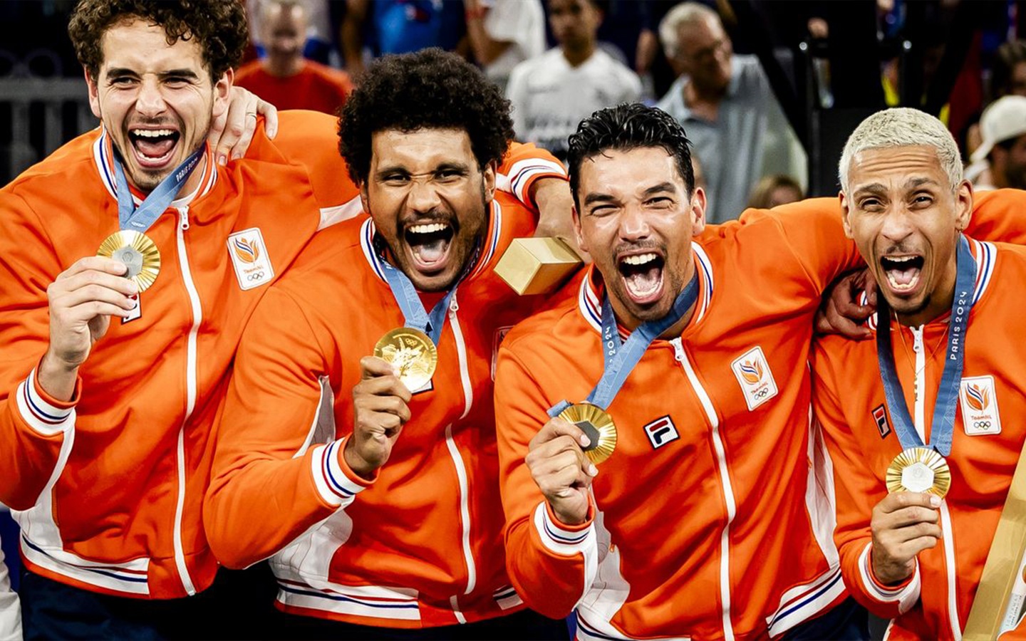 De vier mannen van het Olympisch 3x3 basketbalteam houden hun gouden medaille in hun hand en juichen