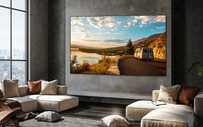 Een 98 inch Supersize TV is gemonteerd aan de muur in een huiskamer. Op het scherm wordt natuur weergegeven.