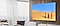 We zien een aan de muur bevestigde Samsung TV met drie vrouwen die door de woestijn lopen en een pot op hun hoofd zetten.
