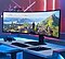 A neon gaming setup. Screen shows a wide view of the game map.