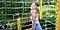 Millie Bobby Brown smiling with her eyes closed inside of her fenced-in garden.