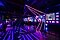 Influencers gathered in the Creators Lounge event space. You can see a colorful light installation in the front and a DJ stage and bar in back.