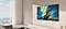 A large Samsung OLED TV hangs against the wall in a bright, modern living room.