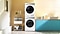 There’s a white Bespoke AI™ washer and dryer set with Morning Blue-colored panels next to a blue cabinet with a sink. The dryer is stacked on top of the washer.