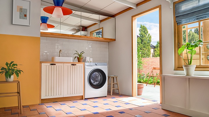 A woman is enjoying the tea time in the kitchen where is placed the stacked washer dryer combo.