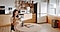 Una mujer está sentada en una cocina equipada con varios electrodomésticos Samsung y tomando notas en su smarpthone celular.