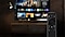 El control remoto SolarCell Remote aparece de forma destacada. Detrás del control remoto hay un televisor Samsung que muestra la pantalla de inicio de Smart Hub.