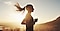 A woman running with the rising sun in the background. The woman's hair is flowing in the wind showing dynamic movement.