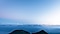 Top view of a mountain range with a clear landscape under blue gradient of clear skies.